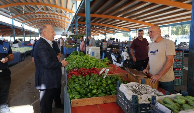 Ali Demirçalı, semt pazarında esnafla yer sofrasında